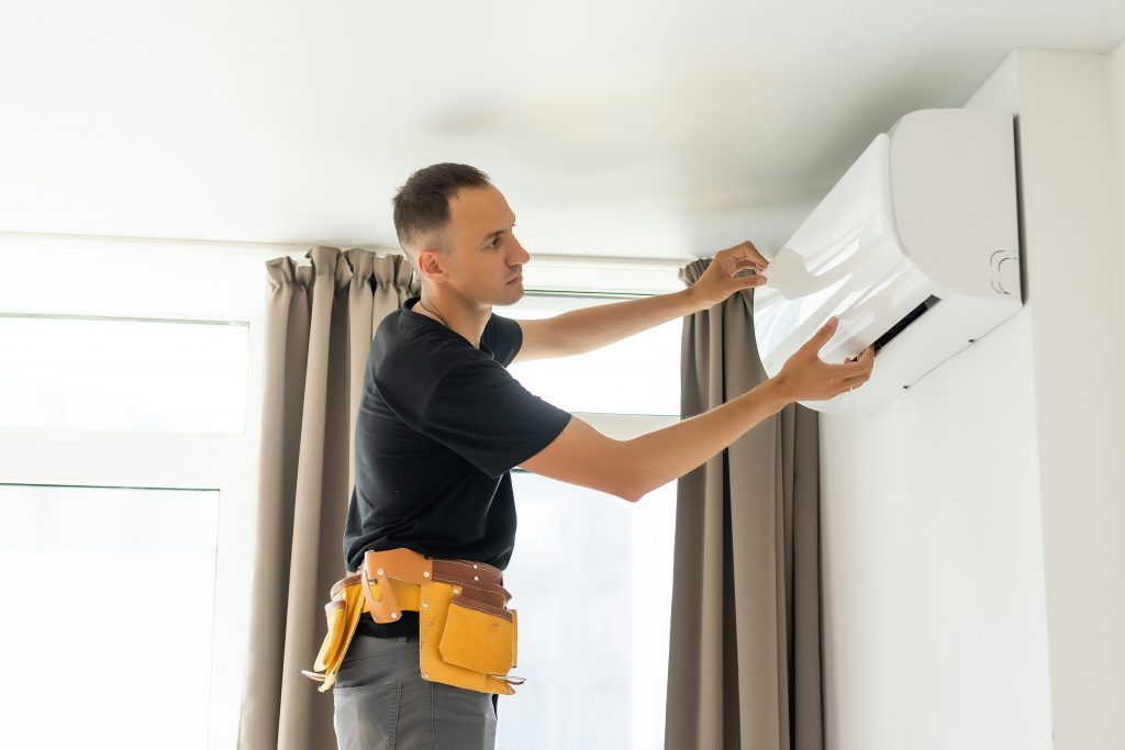HVAC Worker Installing Air Conditioner Unit in Home